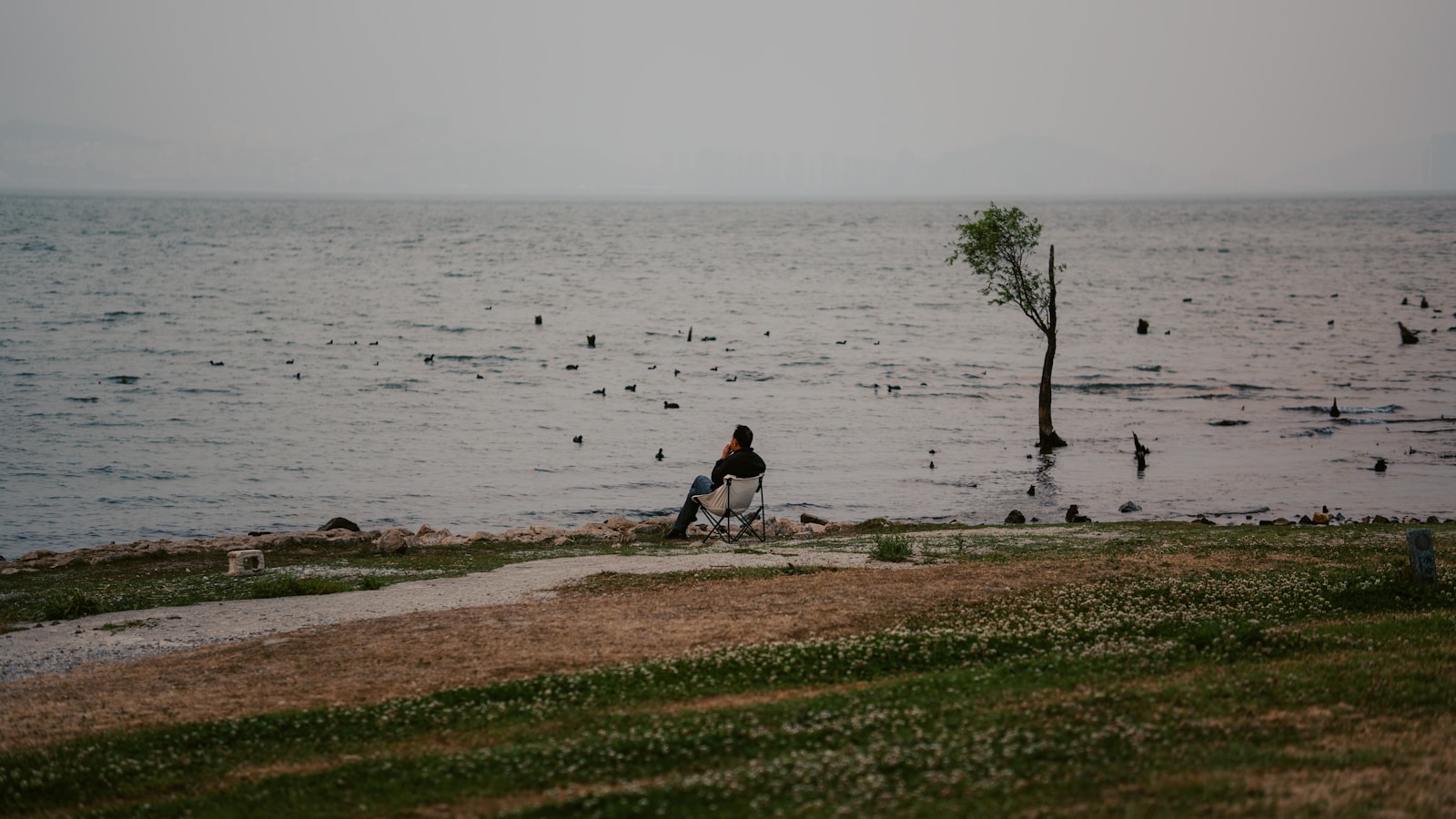 Erhai Lake at golden hour from the west-shore cycle path, the Cangshan Mountains rising behind the water