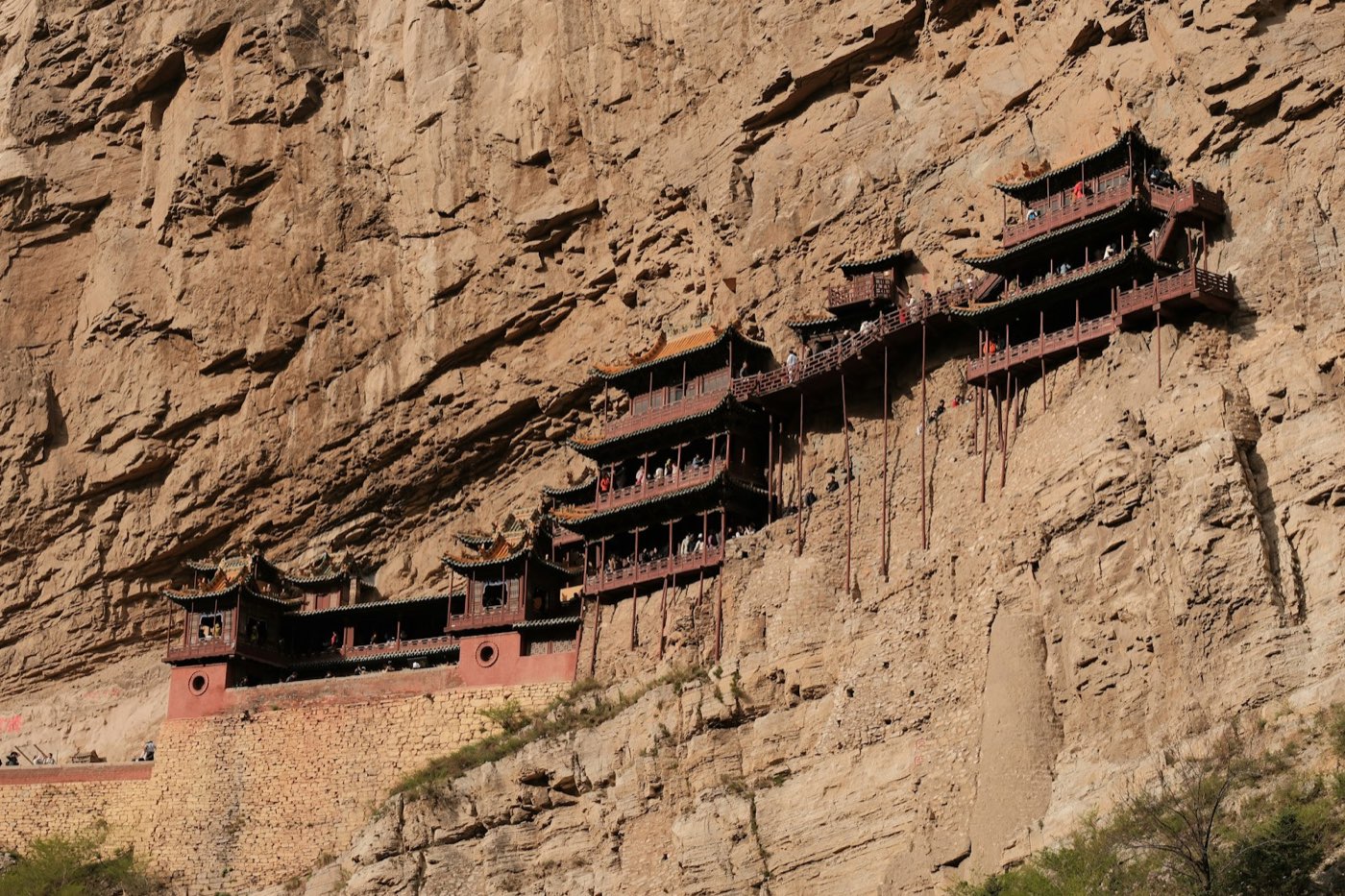 Xuankong Si, the Hanging Temple: dark-roofed red pavilions clinging to a sheer sandstone cliff face at the foot of Mt Heng, propped on slender wooden poles