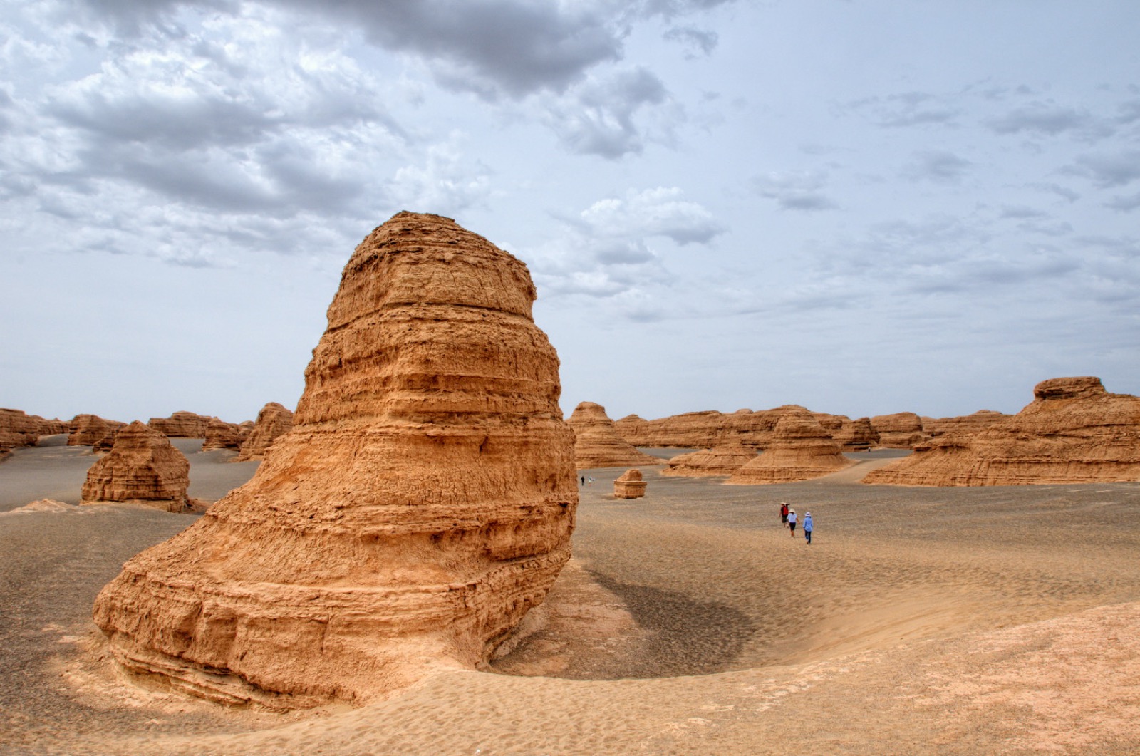 Wind-eroded yardang rock formations rising from the flat Gobi desert at golden hour, long shadows across the gravel plain