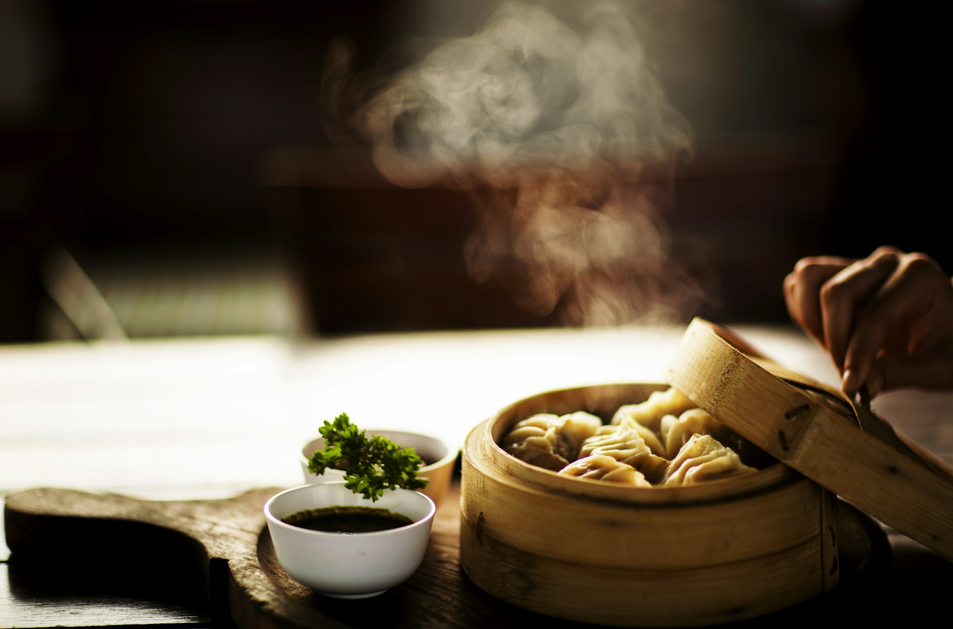 A bamboo-steamer spread of Cantonese dim sum — translucent har gow shrimp dumplings, siu mai, BBQ-pork buns and egg tarts, with a pot of tea