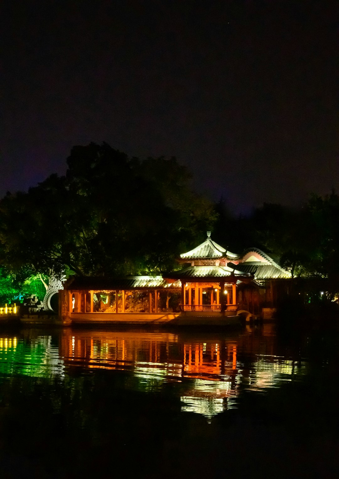 Yangshuo West Street at night — neon signs, red lanterns, and travelers on the ancient stone lane