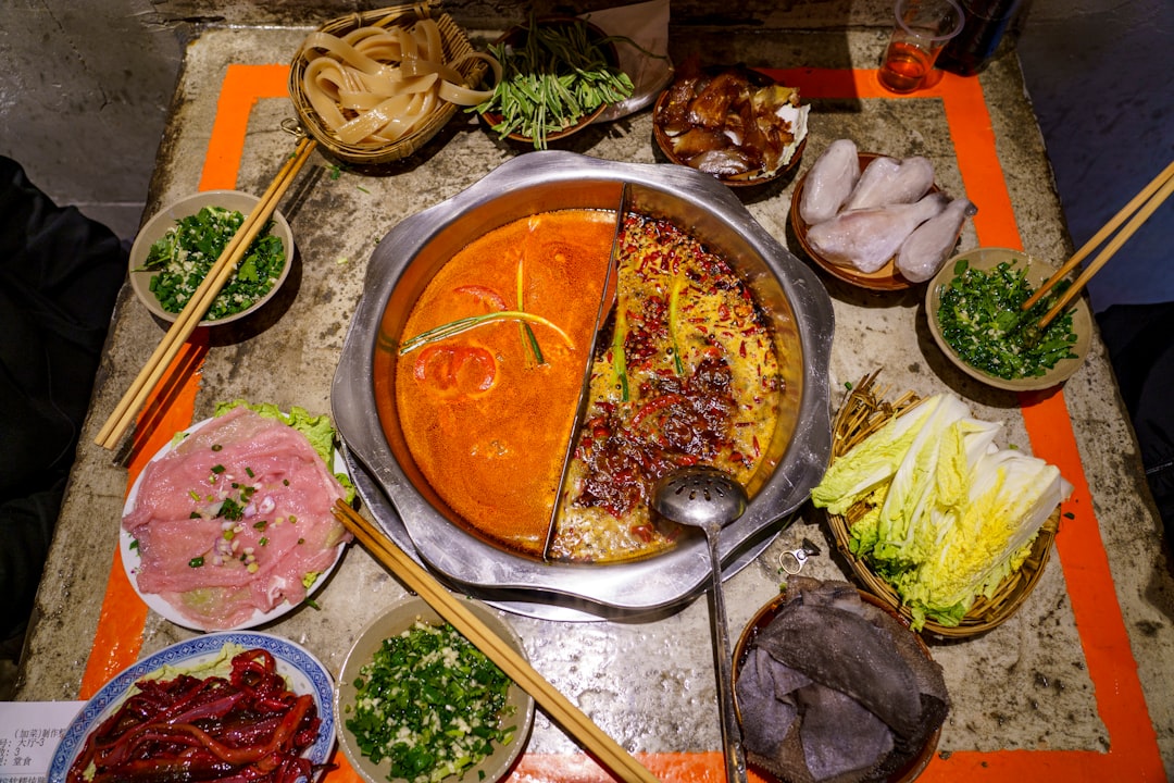 Sichuan mala hotpot — bubbling red beef-tallow broth, raw beef and tripe laid out