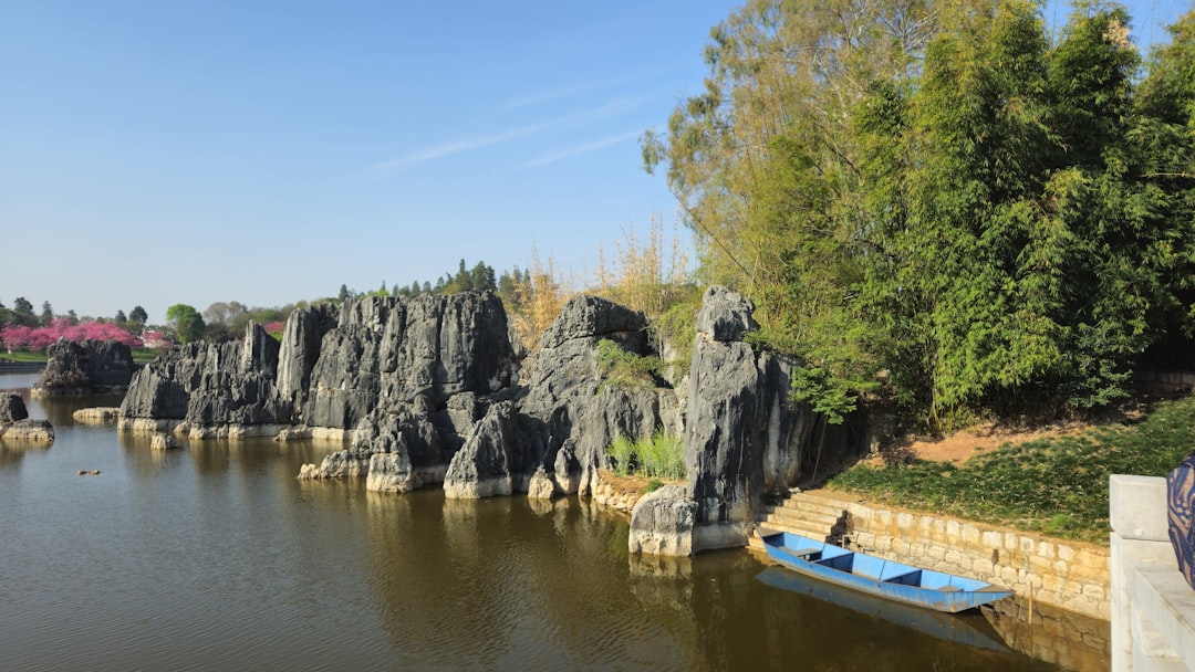 Towering karst pillars of the Stone Forest, sunlight cutting between 30-meter limestone columns