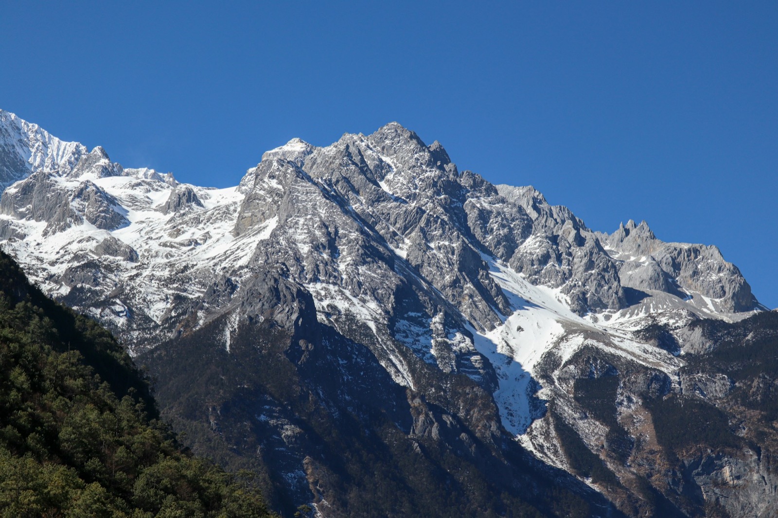 The Glacier Park cable car climbing toward the 4,506 m platform on Jade Dragon Snow Mountain, snow and rock above the tree line
