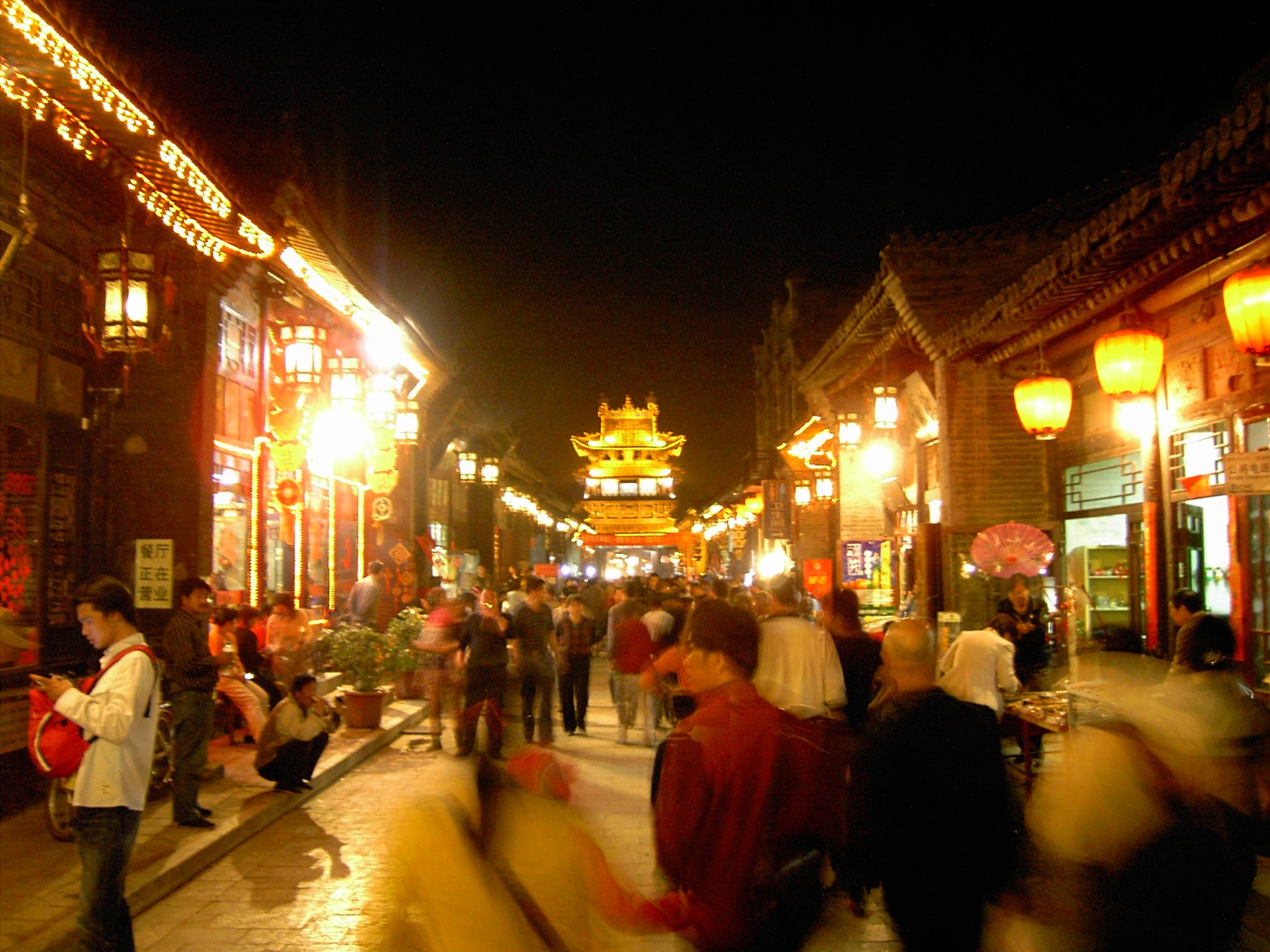 The atmospheric staged street-set of the Youjianpingyao immersive performance, lanterns and costumed cast