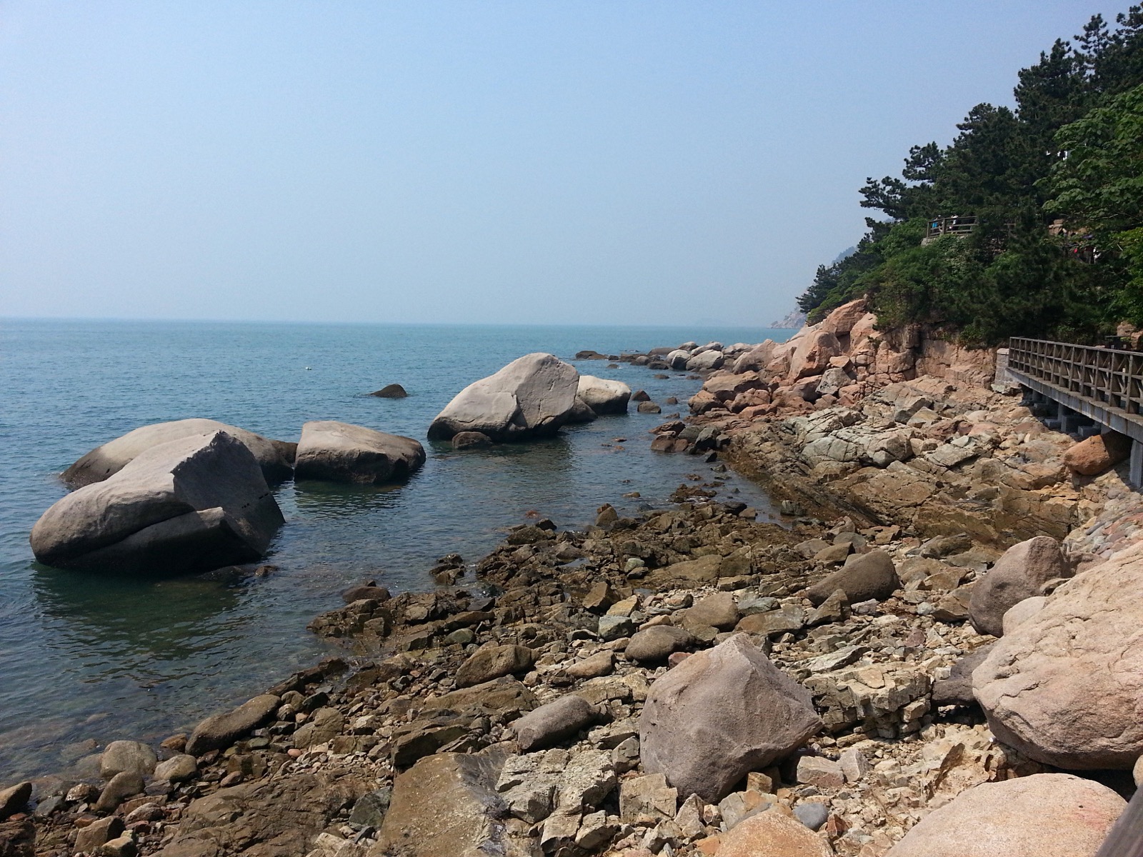 Laoshan granite peaks dropping straight into the Yellow Sea, with a Taoist temple below