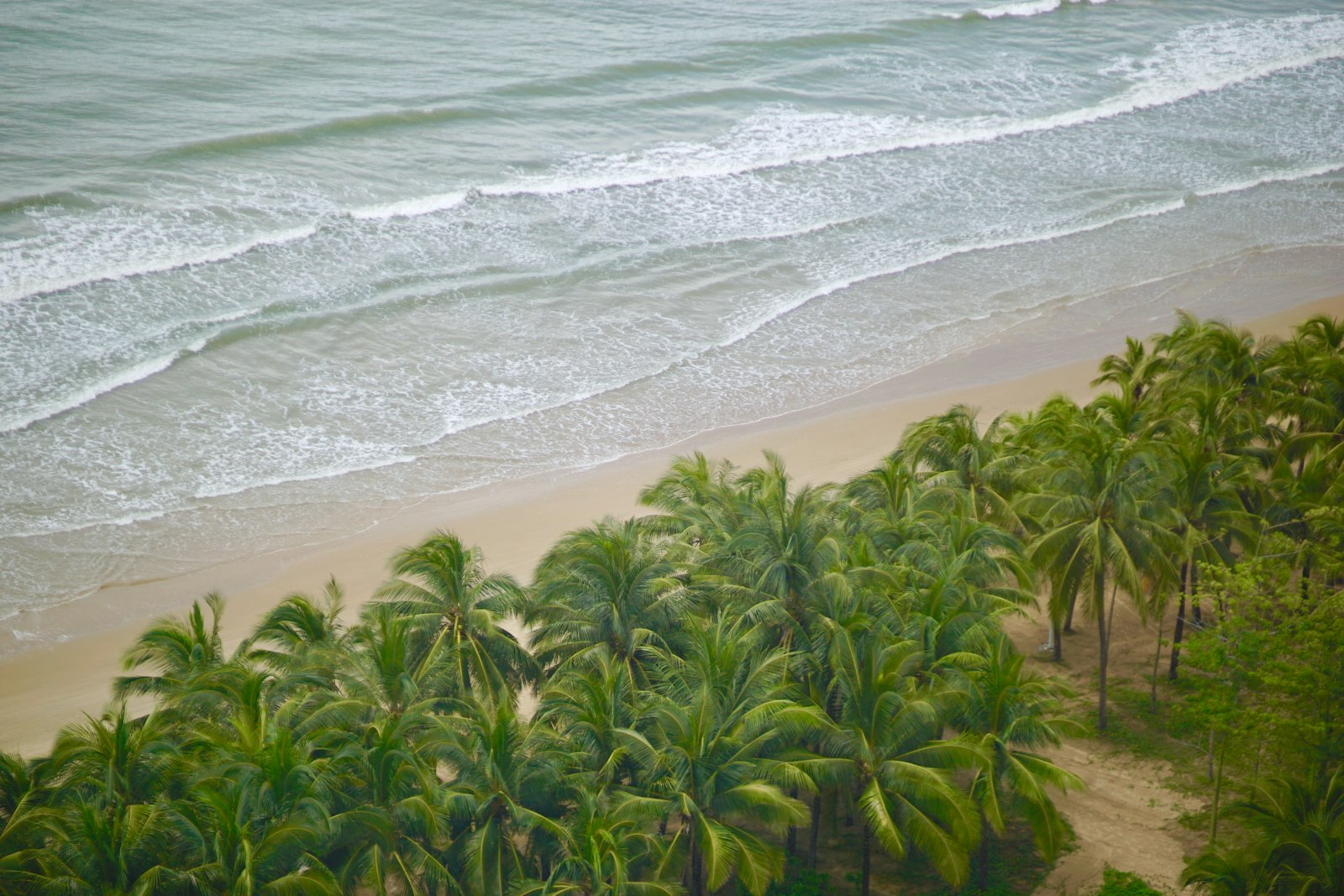 Yalong Bay's crescent of white sand and turquoise water backed by resort towers — Sanya hero shot