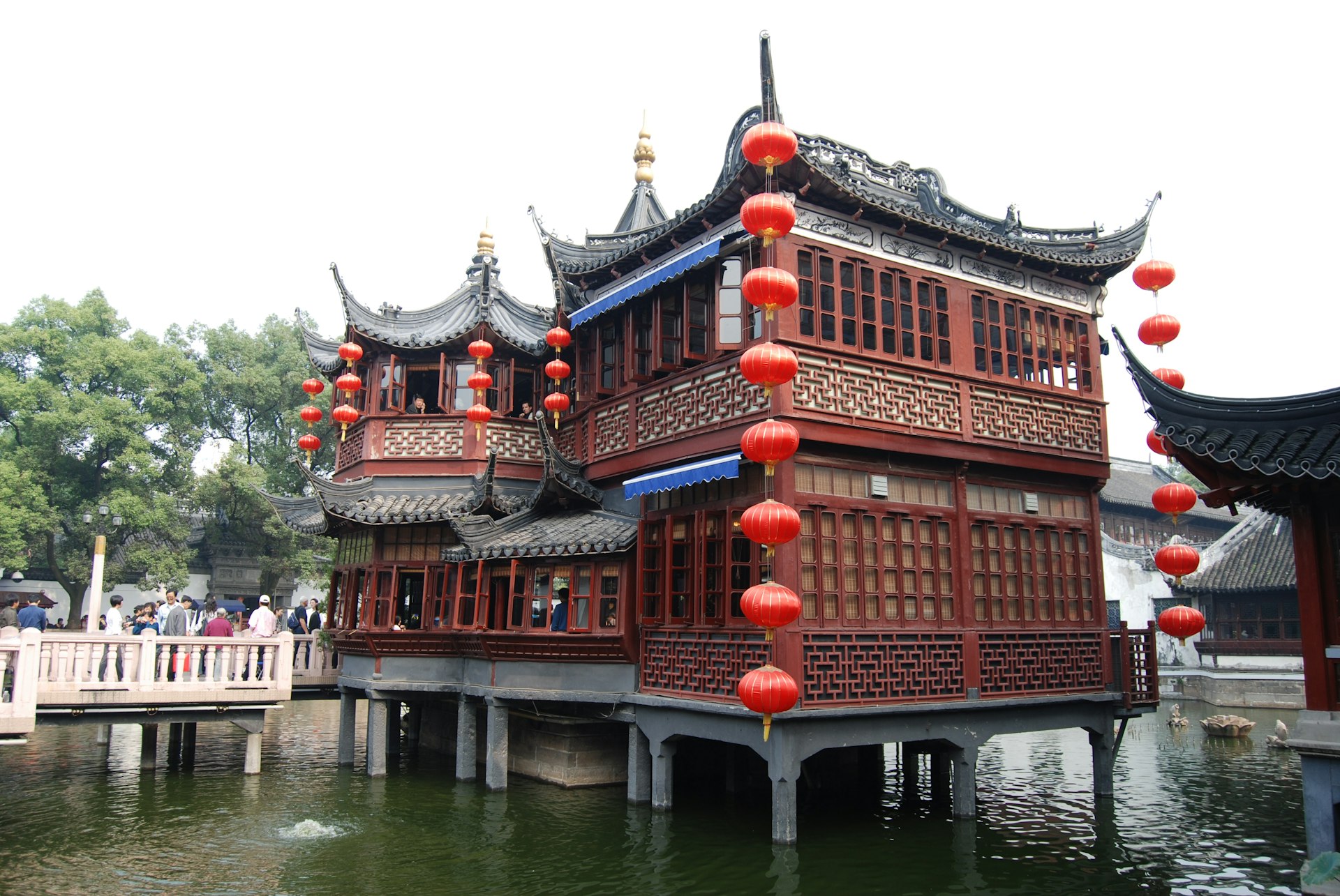Yu Garden's classical Ming-dynasty rockeries, koi ponds and upturned pavilion eaves, with the Huxinting teahouse and zigzag bridge nearby