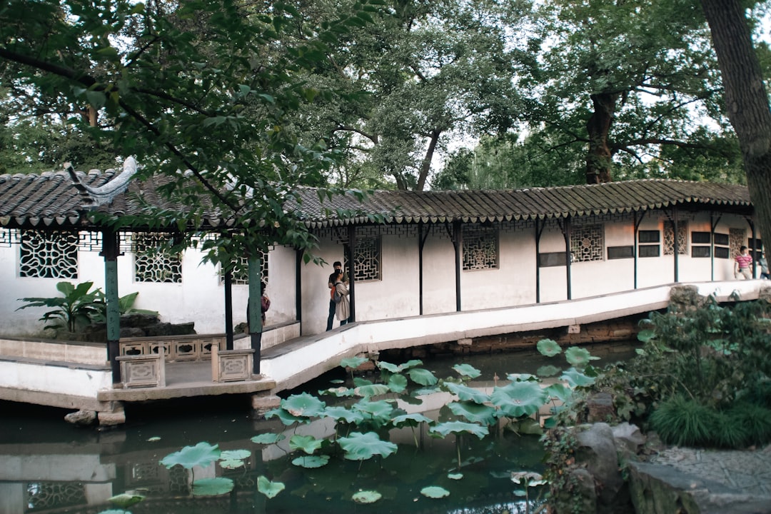 Humble Administrator's Garden — white walls, lotus pond, and moon gate framing a pavilion