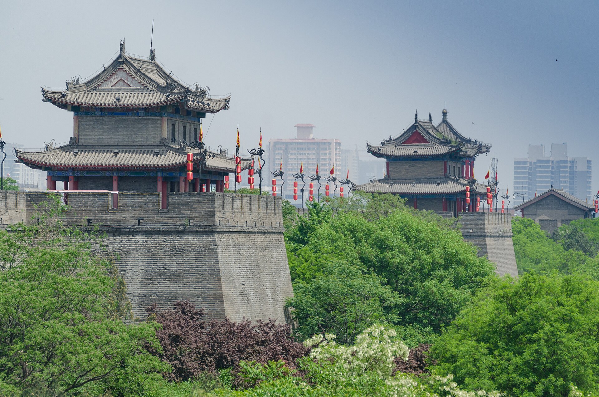 Xi'an's illuminated Ming-dynasty city wall at dusk, watchtowers and lanterns glowing over the old town